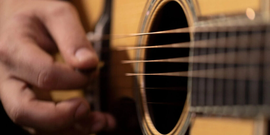 Zbliżenie na struny Martin podczas gry na gitarze.